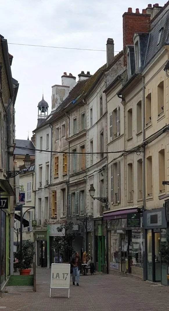 Rue avec boutiques et bâtiments anciens en Europe.