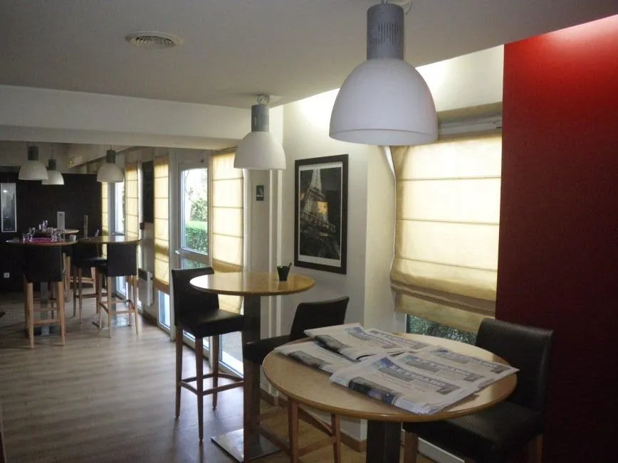 Salle à manger moderne avec tables et lampes suspendues.