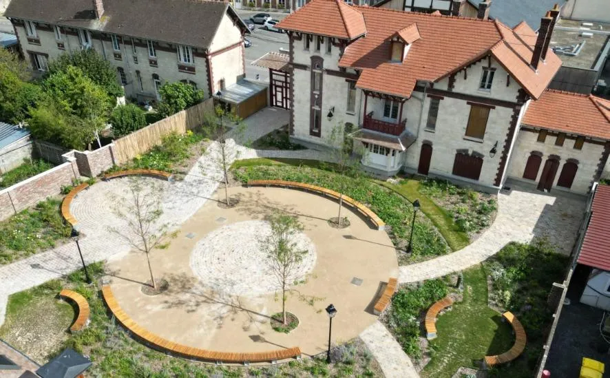 Maison ancienne avec cour circulaire et jardins paysagers.