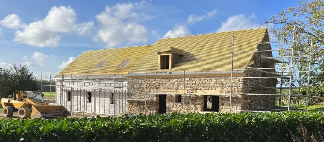 Maison en construction avec échafaudages.