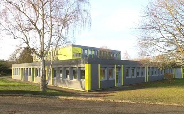 Bâtiment moderne avec façade verte et grise.